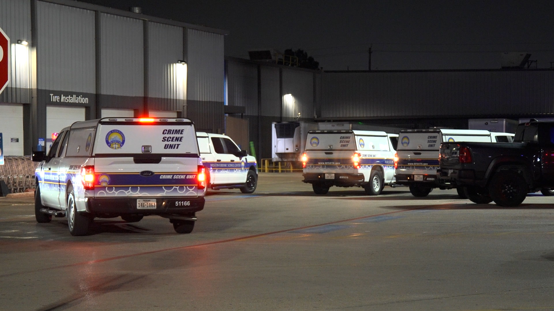 Nighttime scene with multiple Crime Scene Unit vans parked in a loading lot outside an industrial building.