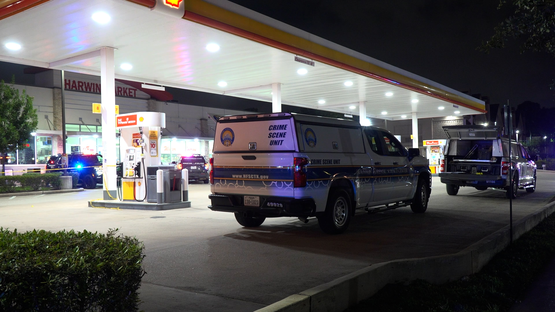 Crime Scene Unit van at a gas station at night, with police cars nearby and a truck trailer in the background.