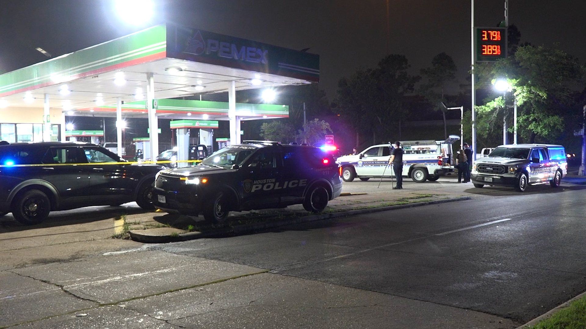 Nighttime gas station scene with Houston Police SUV and taped-off area, multiple police and emergency vehicles present.